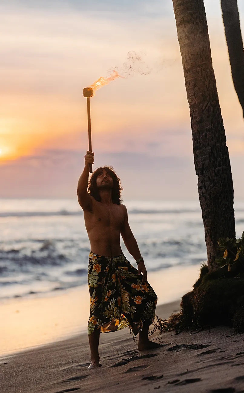Man holding a torch on the beach near Hyatt Vacation Club at Kāʻanapali Beach