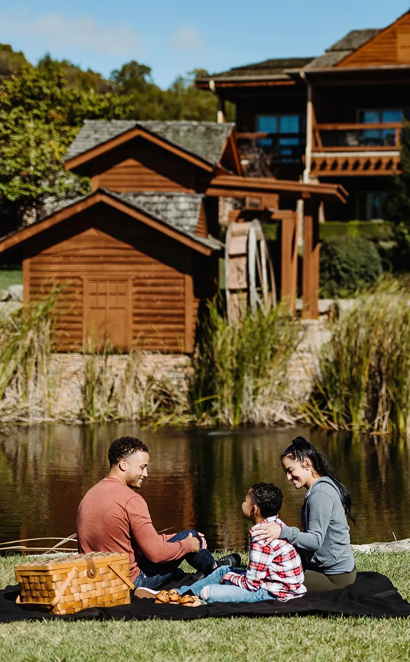 Mother, father, and son with a picnic in front of The Lodges at Timber Ridge