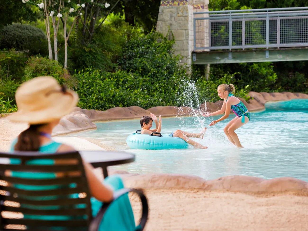 Mother watching children play in pool