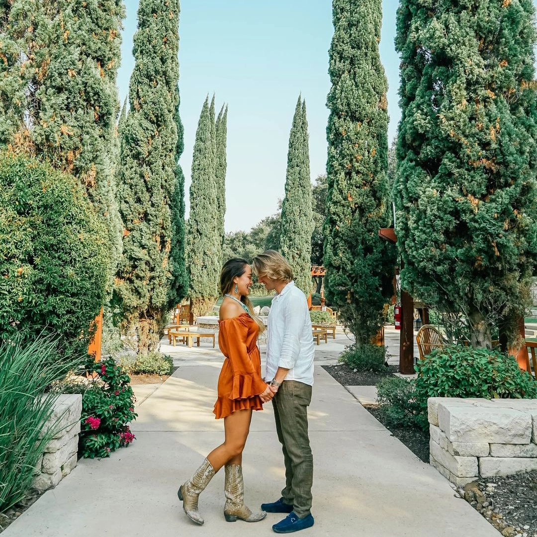 young couple holding hands looking at each other in patio garden