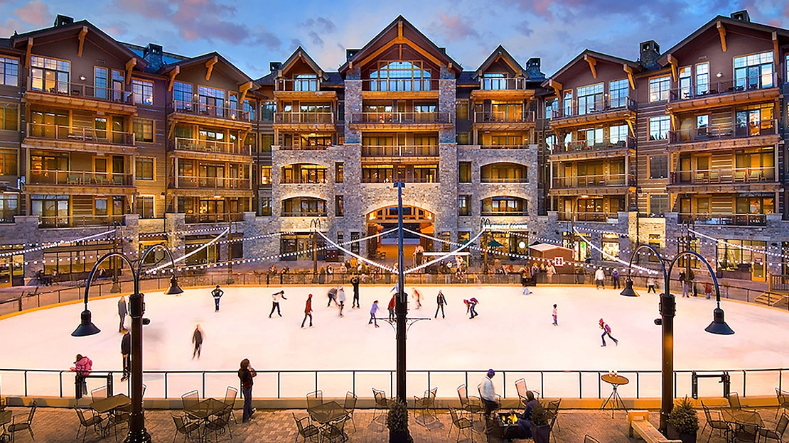 Residents enjoy ice skating in front of a resort during wintertime