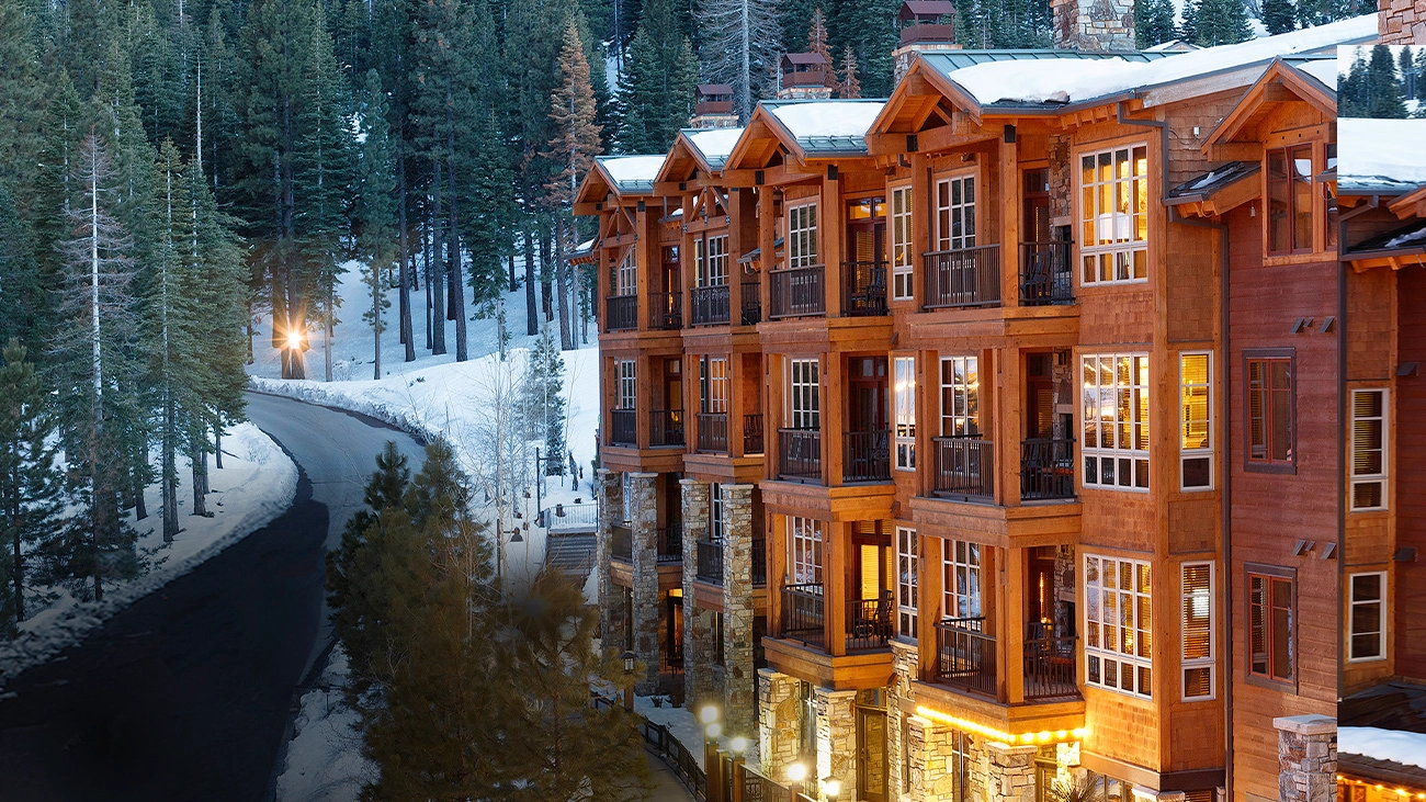 A snow-capped NorthStar Lodge in front of a forest