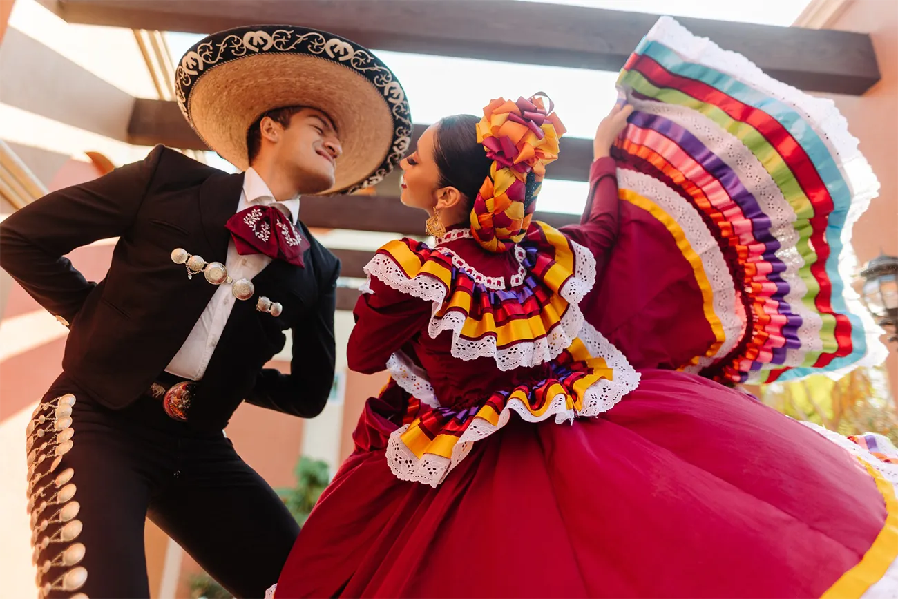 Man and woman in colorful outfits dancing in Cabo San Lucas