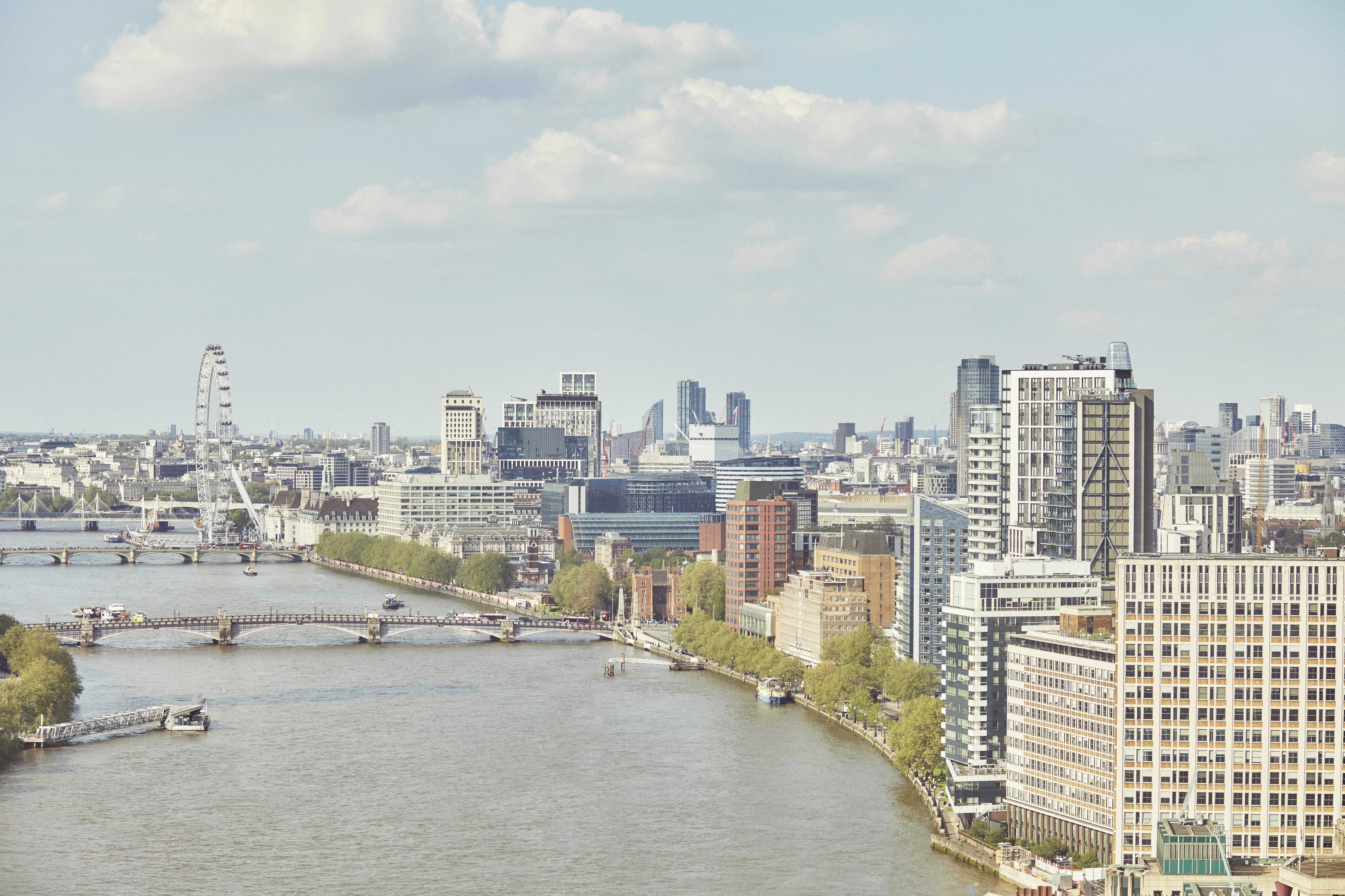 Contemporary suite with East River view through large windows.