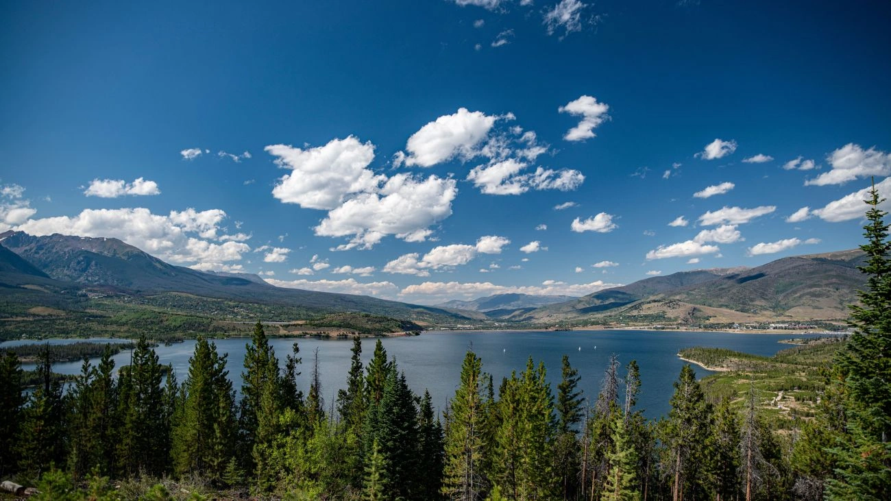 A wide panoramic view of Lake Dillon, evergreen forests, and rolling hills. 
