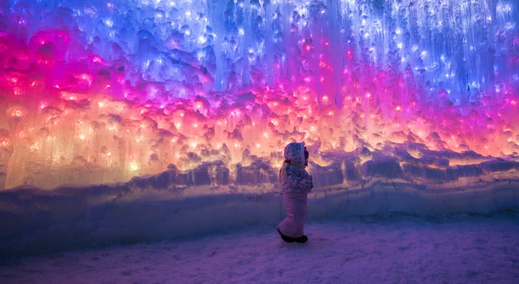 Person standing in colorful ice castle