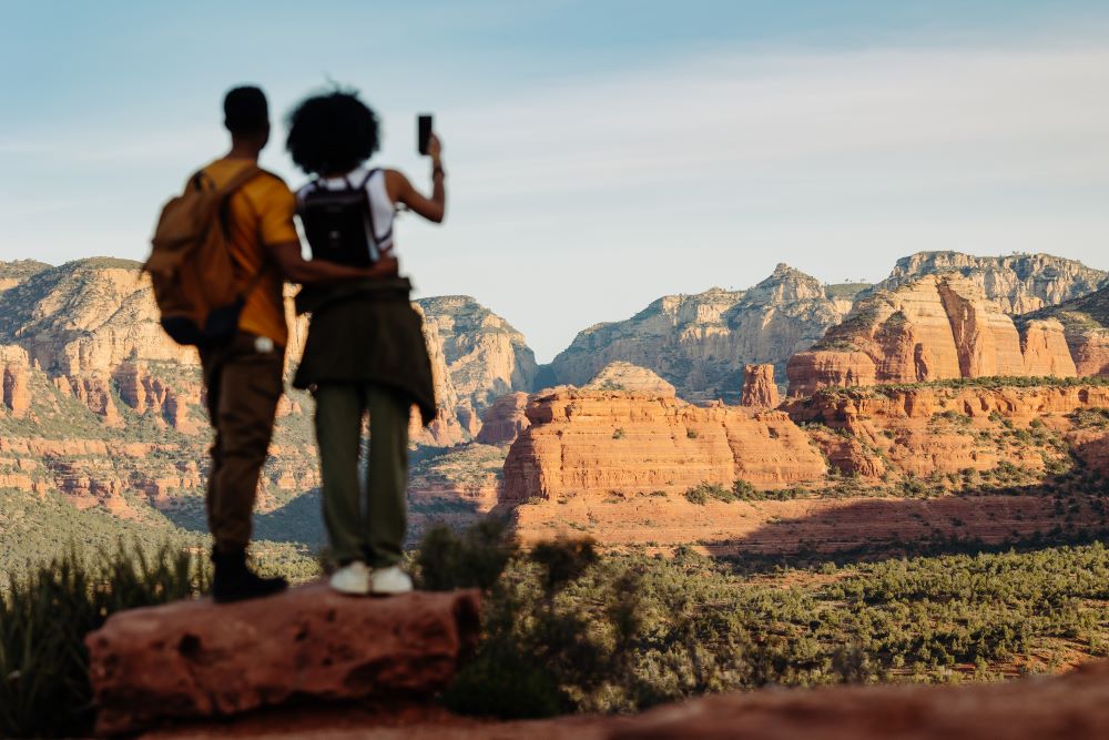 A couple takes a photo of a specatcular Arizona landscape.
