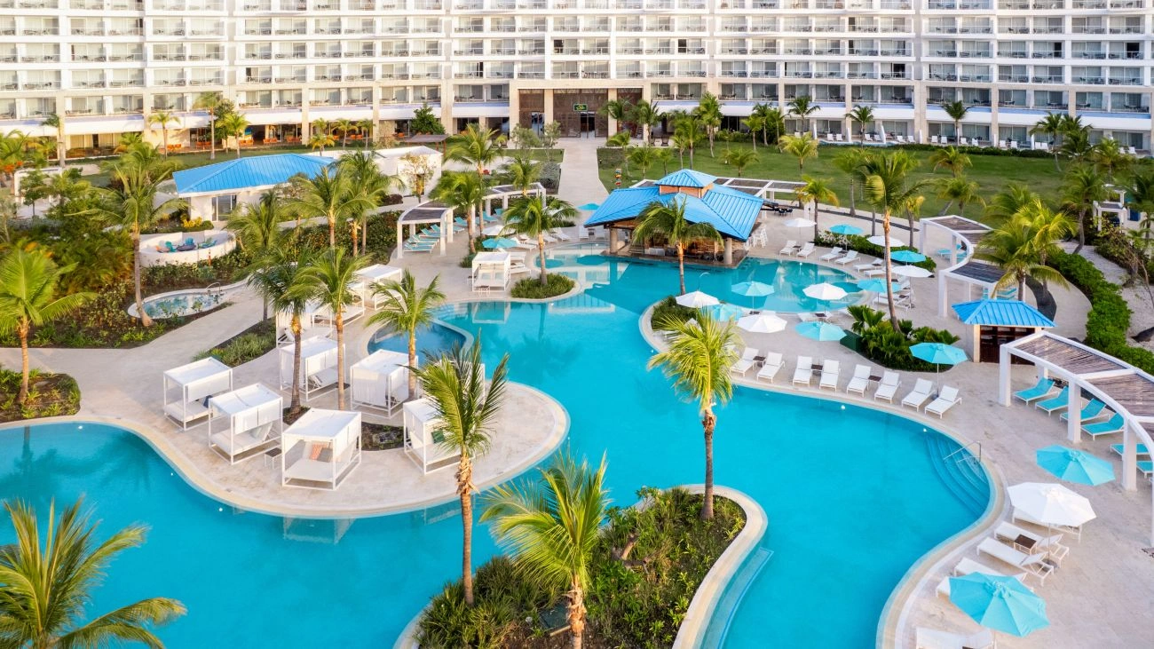 Palm trees and cabanas surround interconnected pools at the Dreams Cap Cana Resort & Spa.