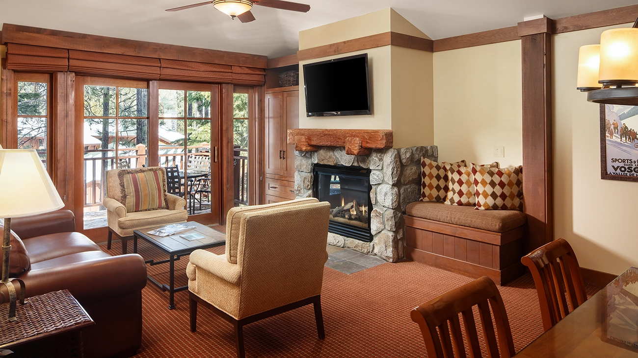 Comfy chairs and a couch in front of a fire in the villas sitting area
