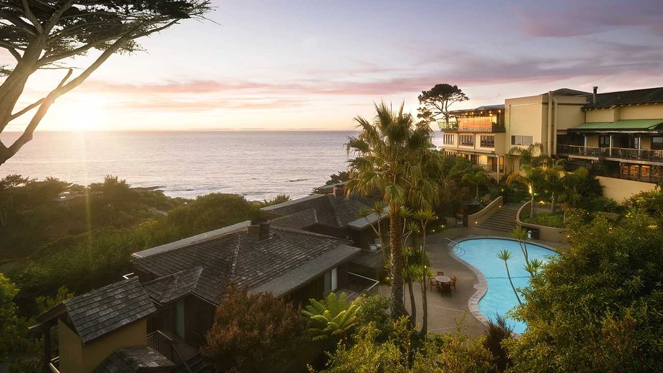 The sun sets next to the Highlands Inn resort pool deck