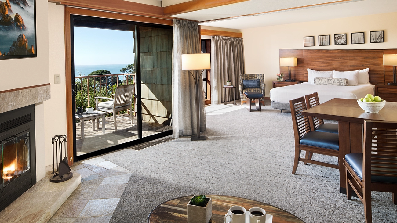 A king-size bed sits in a spacious living area with an attached patio
