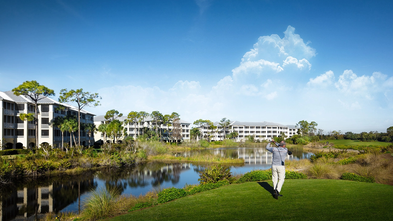 A golfer hits a drive in front of the Hyatt Vacation Club at Coconut Cove resort