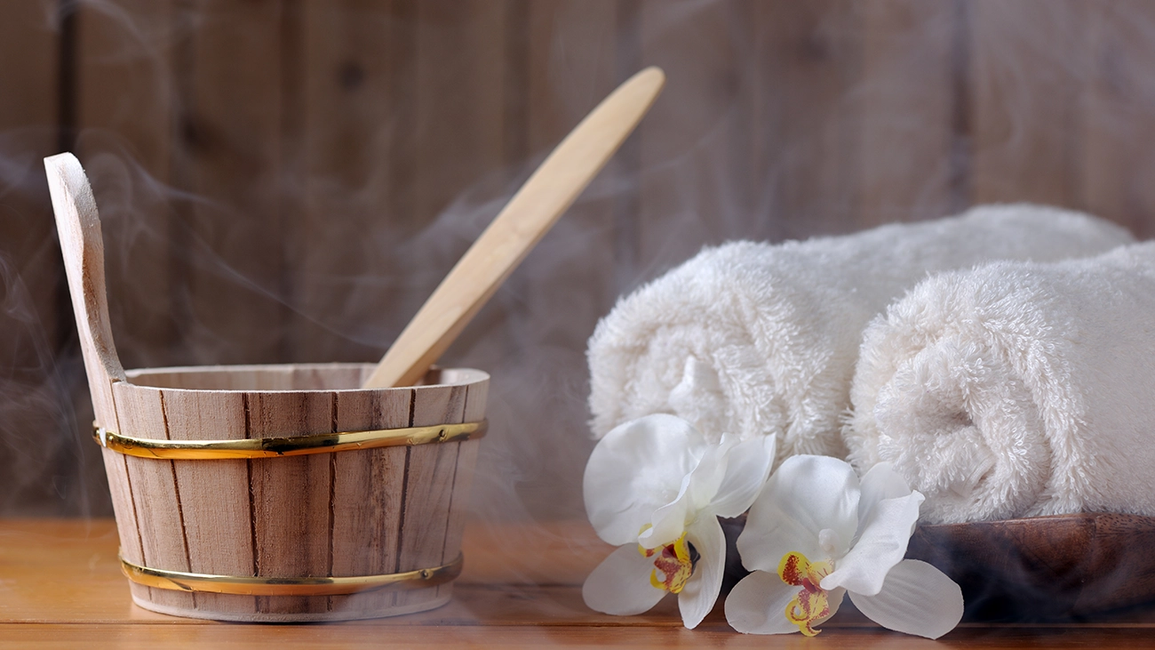 A wooden water bucket and steam towels in a sauna