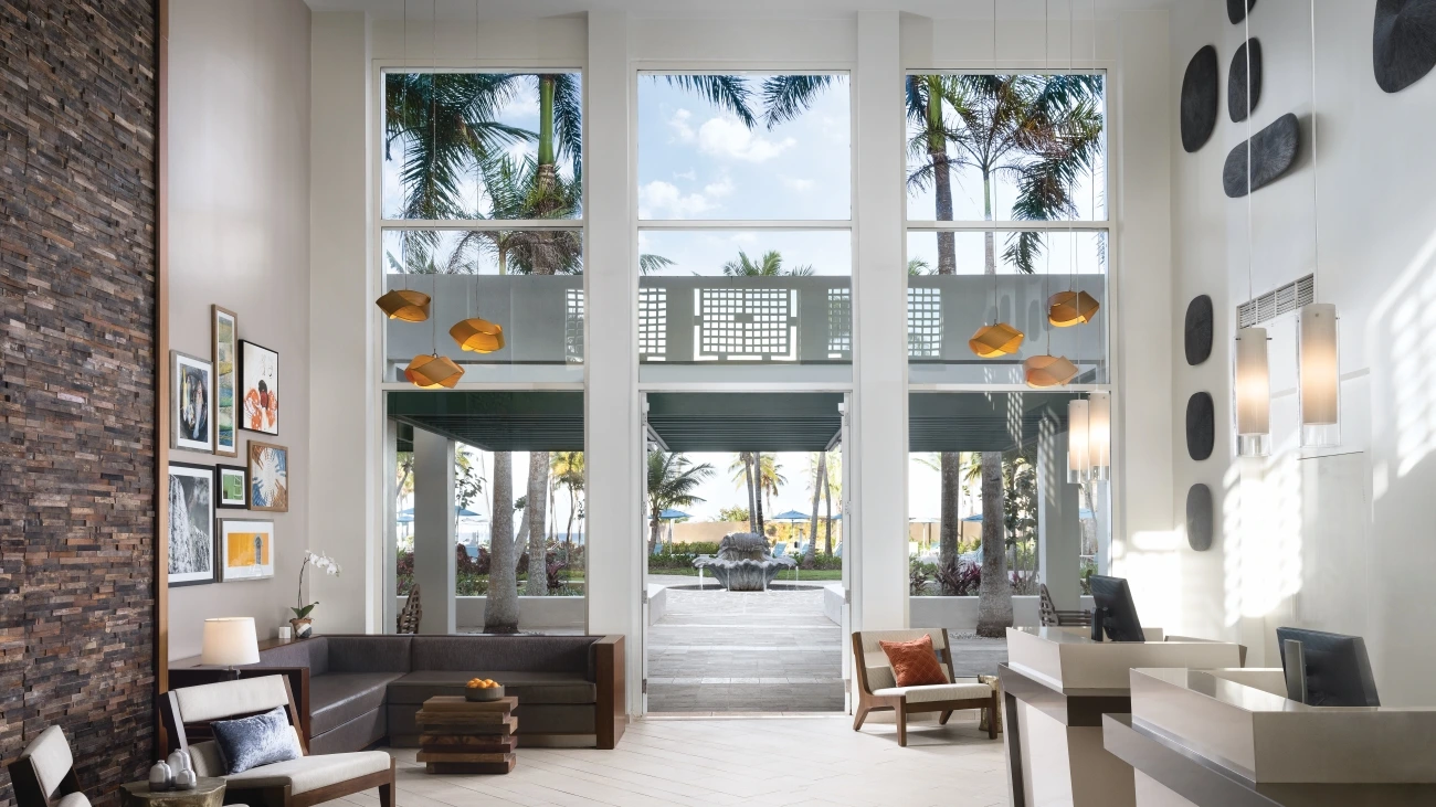 A white room with art, sofas, and floor-to-ceiling windows