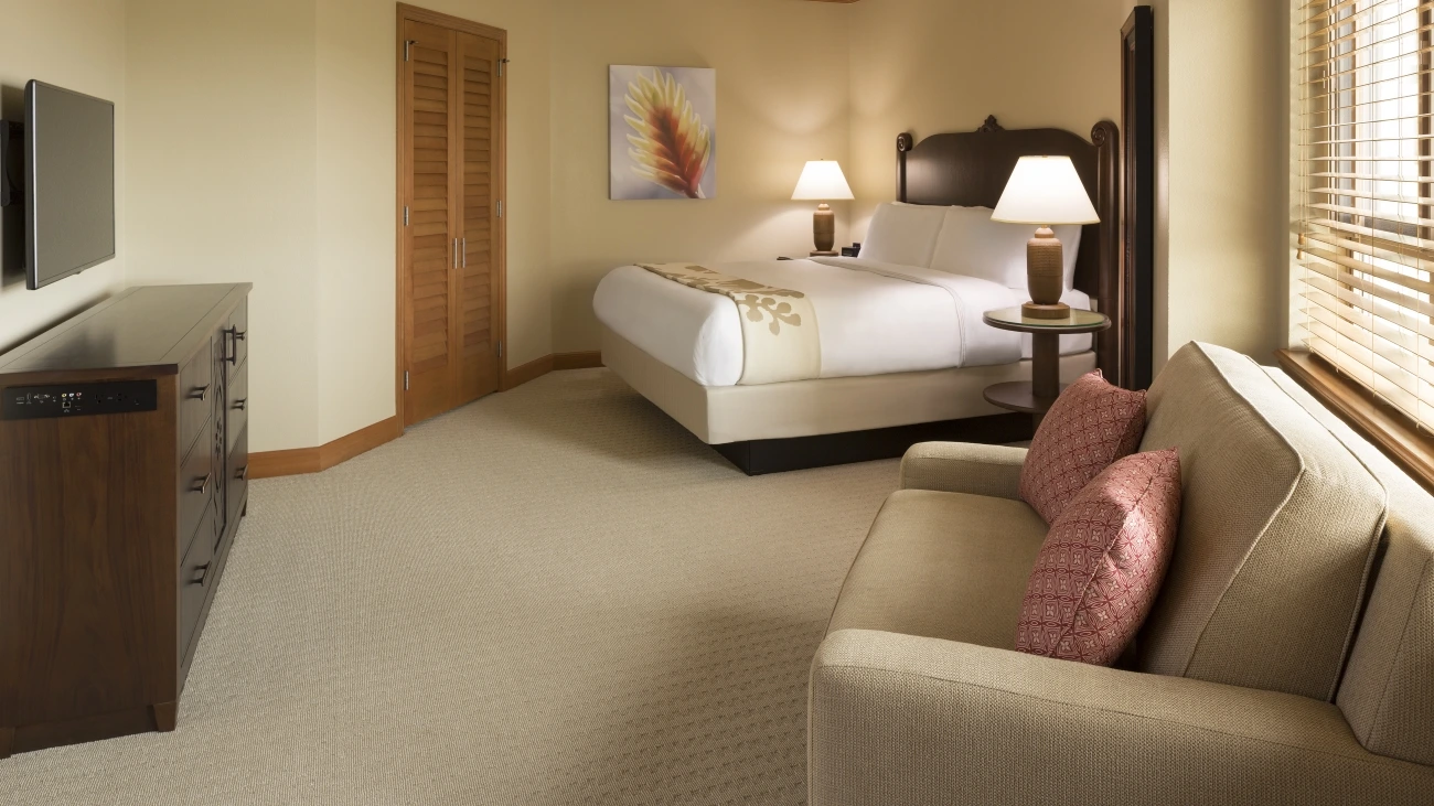 Villa bedroom with bed, loveseat, dresser and HDTV