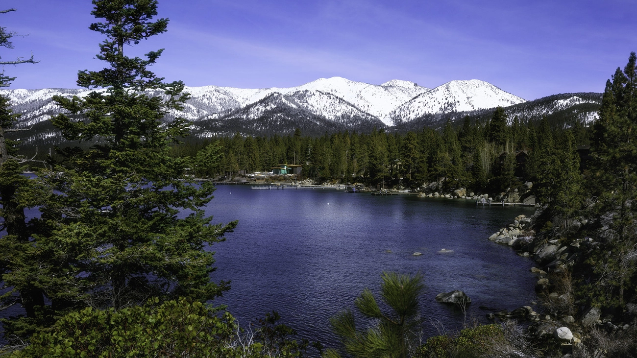 Shimmering Lake Tahoe, with pine trees and snow-capped mountains 