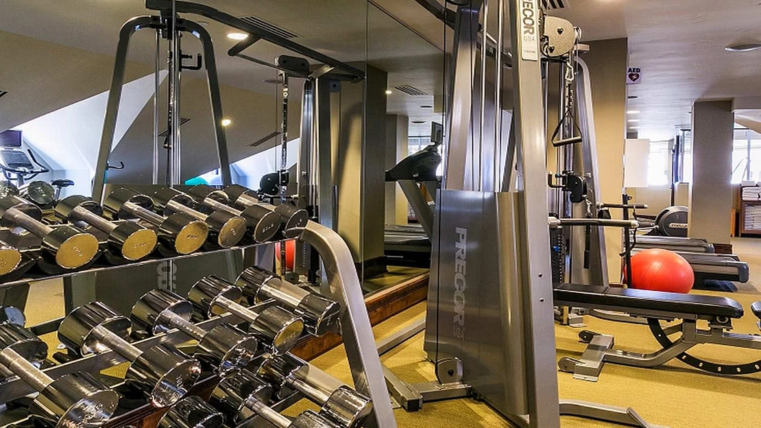 Shining freeweights sit beside an exersize machine in a fitness center
