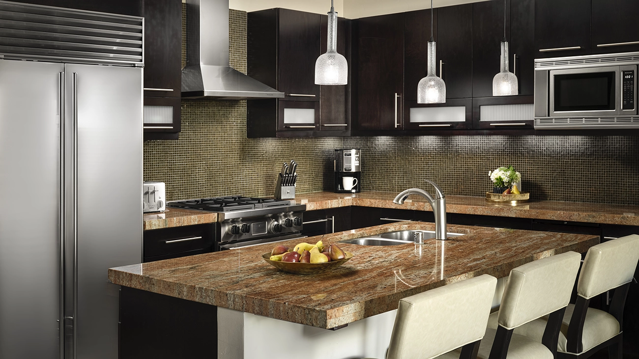 A high-end kitchenette with appliances, a counter, and barstools