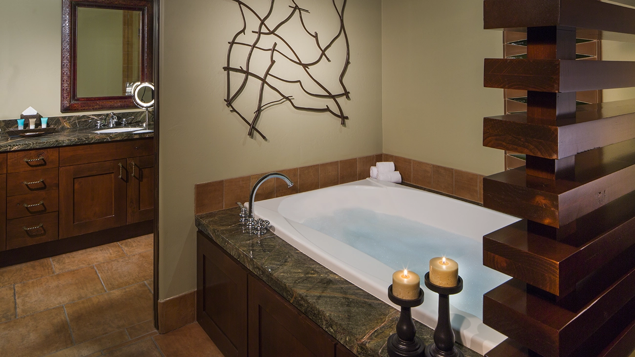 A warm bubble bath is complemented by a pair of candles in the resort bathroom