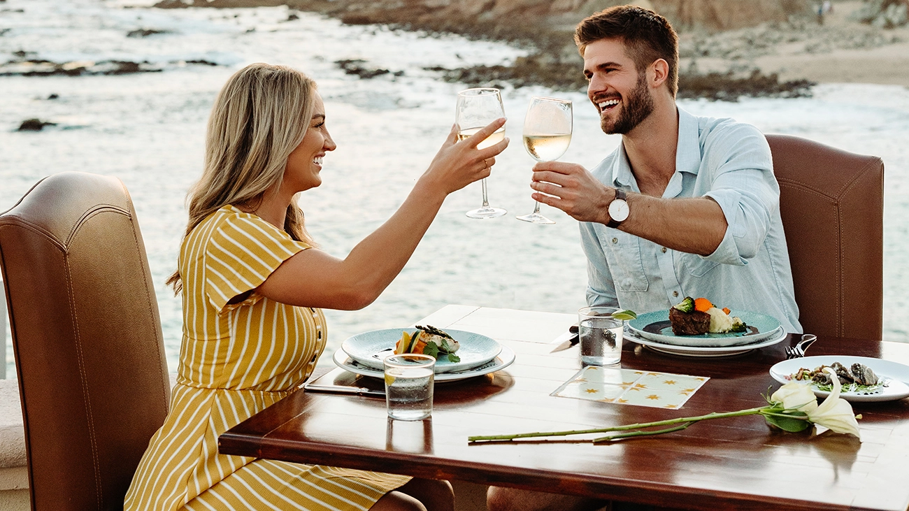 Couple toasting at restaurant overlooking the water at Sirena del Mar