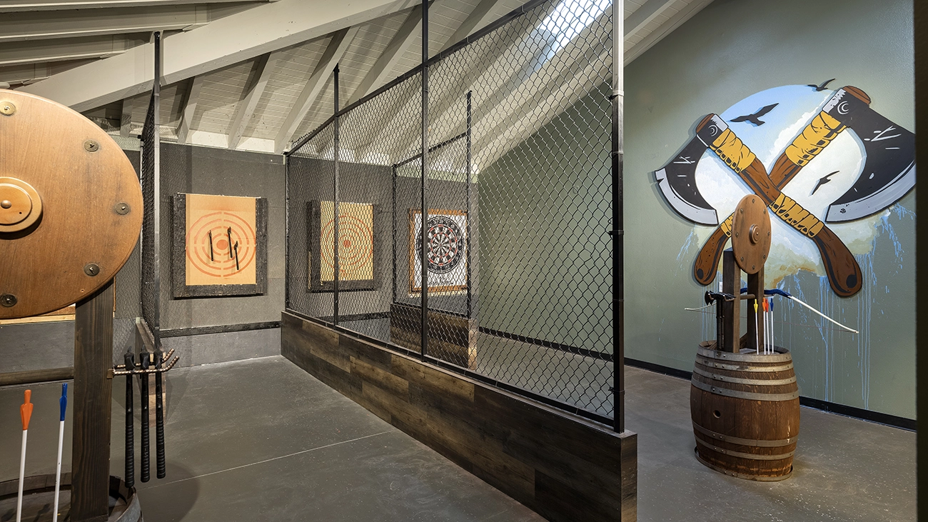 Targets are nailed to a wall at the axe throwing/archery range