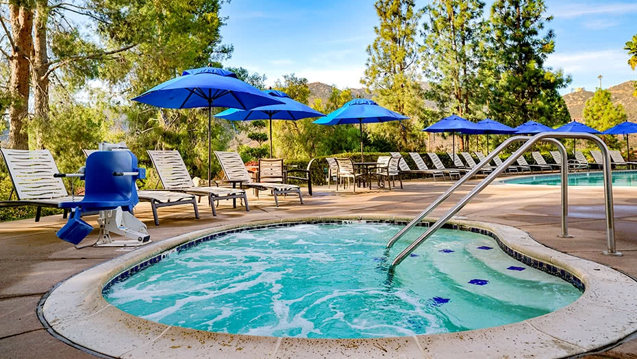 Bubbling outdoor whirlpool surrounded by vivid blue shade umbrellas