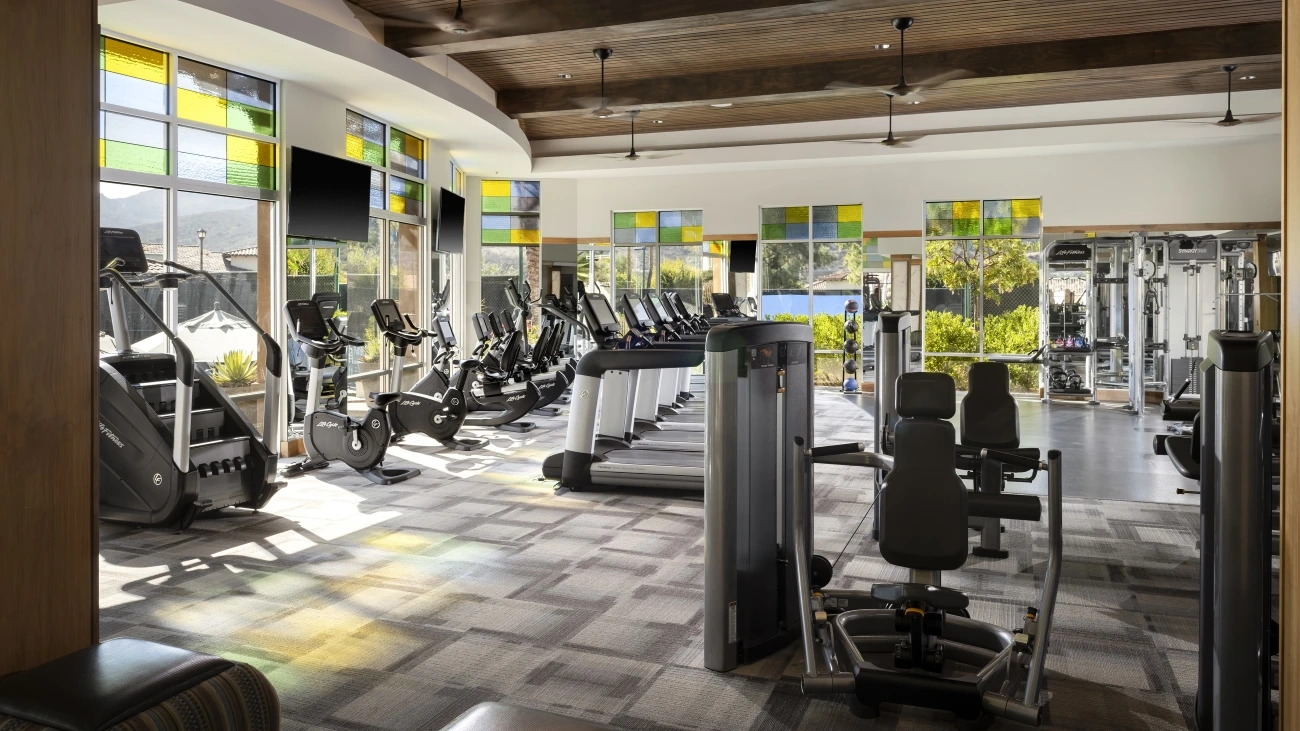 Large workout room with many treadmills and exercise bikes