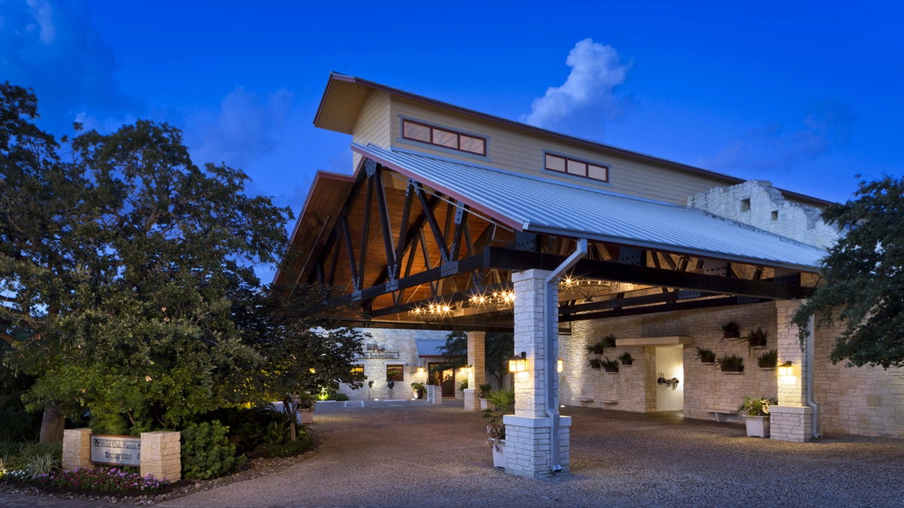 Lights shine brightly at the entrance to Wild Oak Ranch as the sky begins to darken