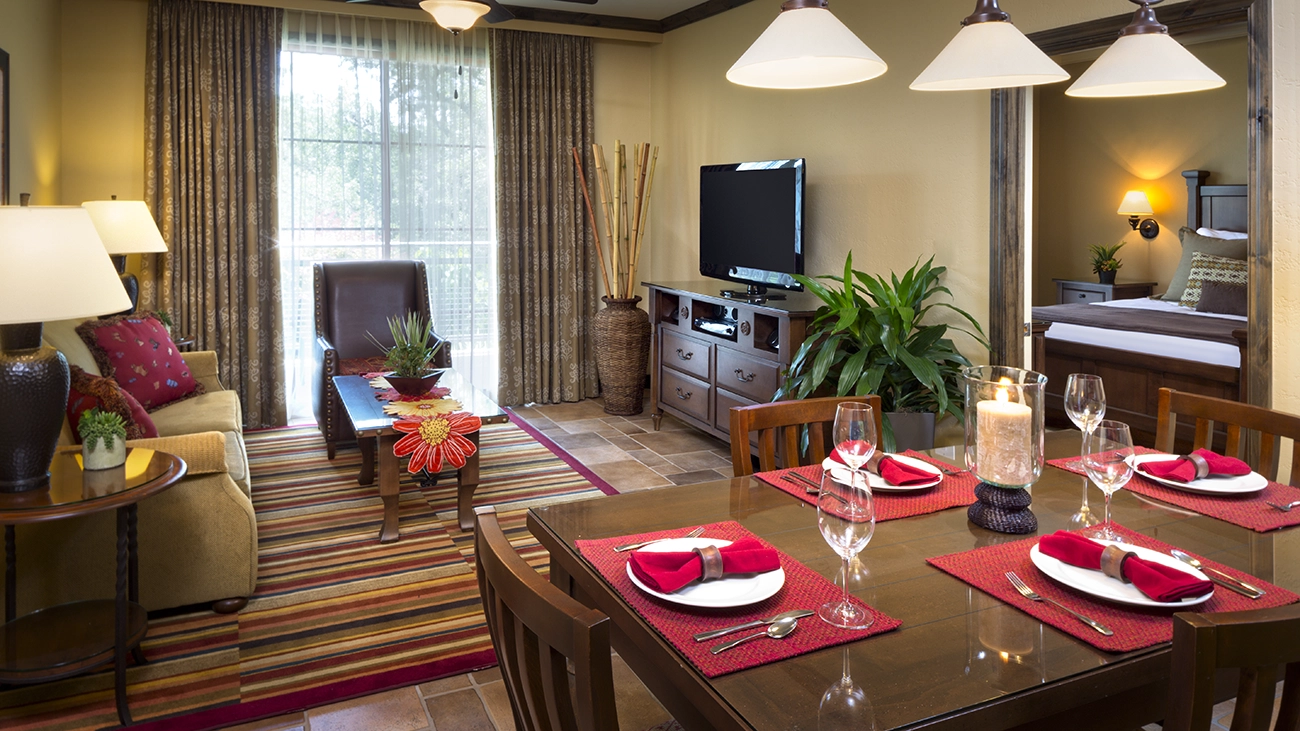 Red napkins and placemats line a dining room table inside of a resorts sitting area