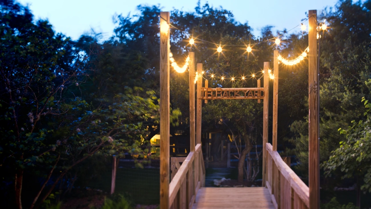 A footbridge with lights to JB's Backyard